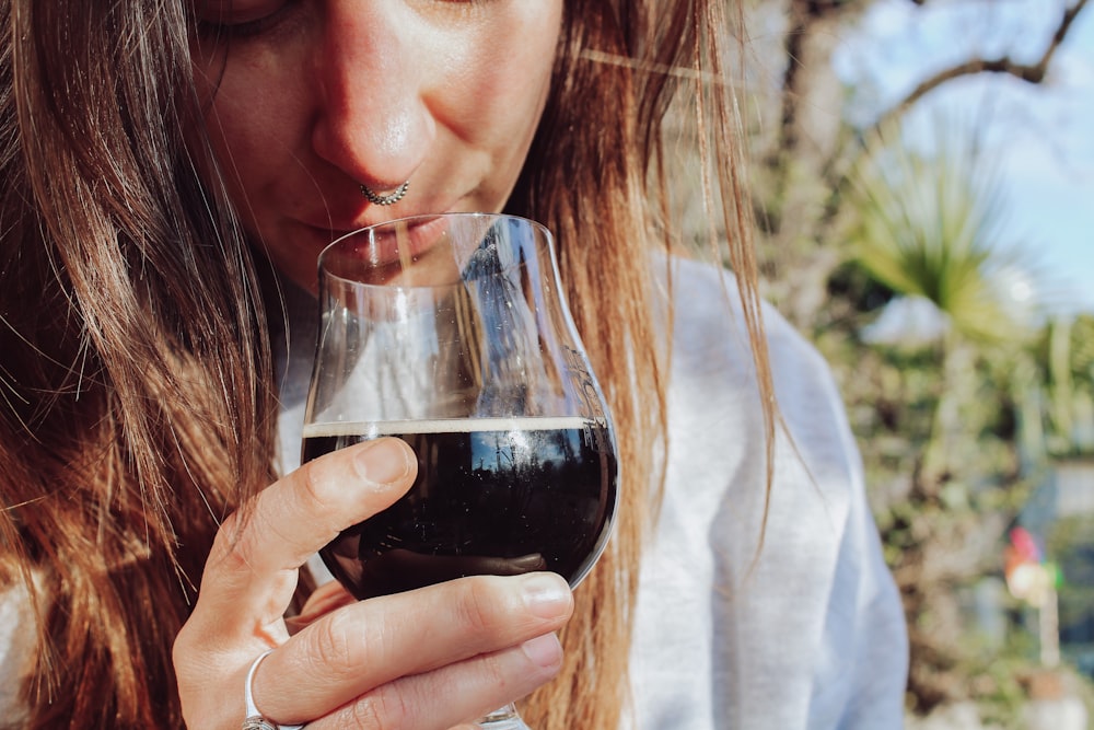 uma mulher que bebe um copo de vinho