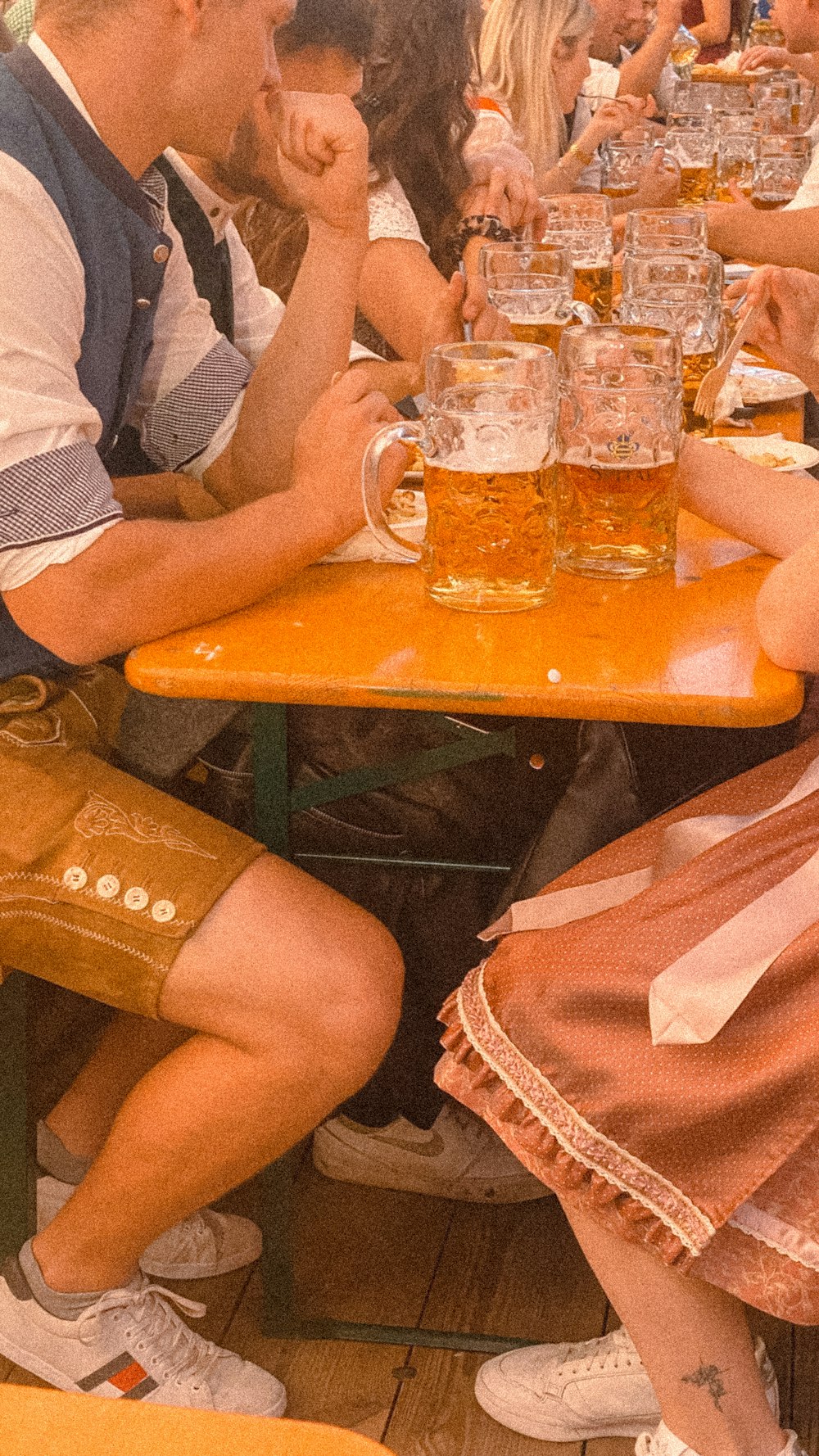 a group of people sitting at a table with glasses of beer