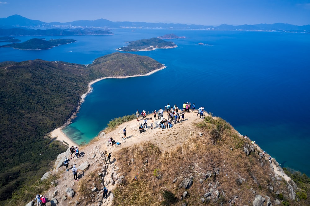 a group of people on a cliff above a body of water