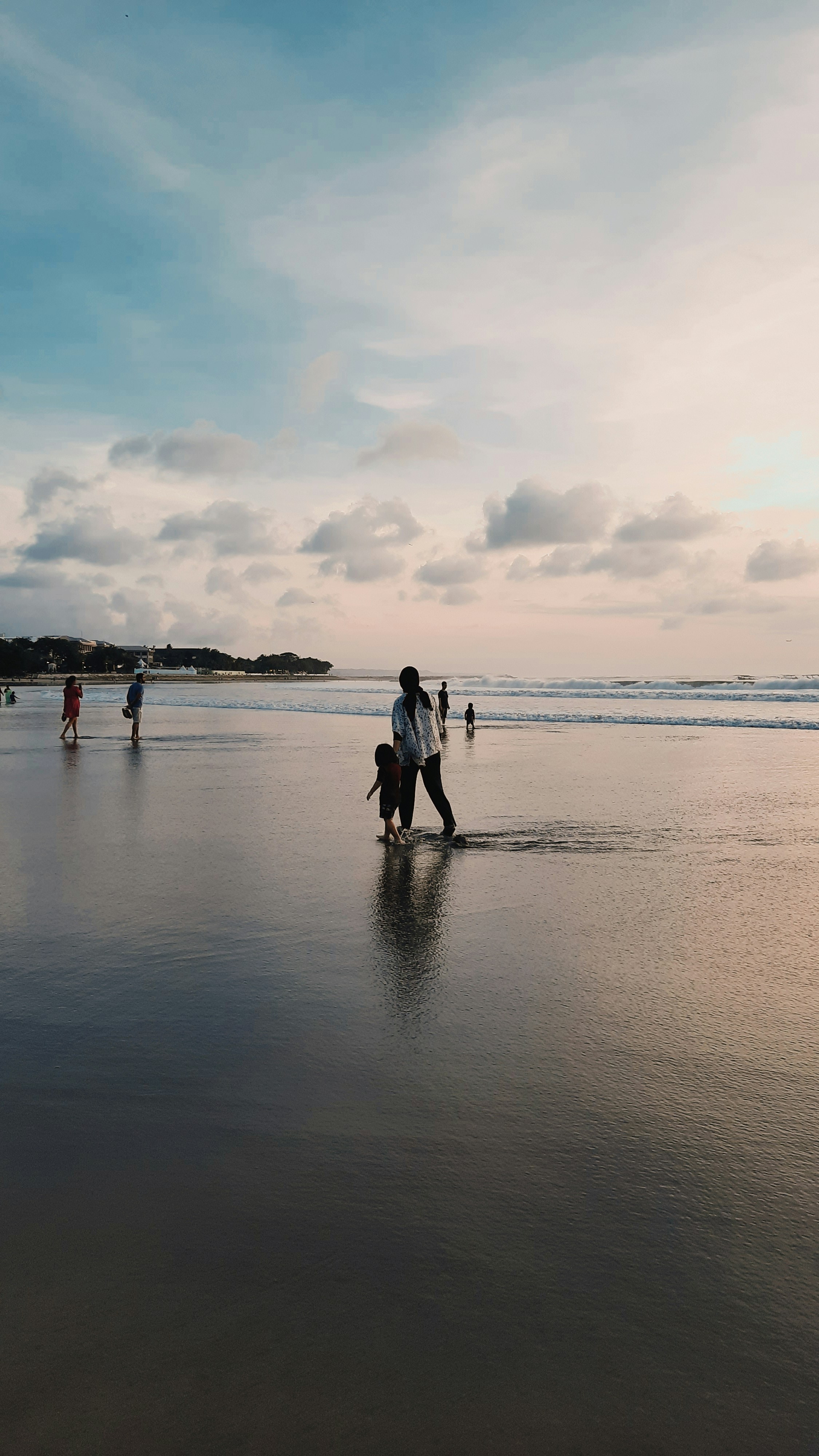 um grupo de pessoas andando em uma praia