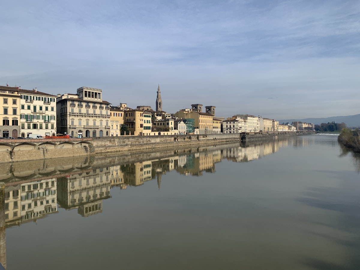 Oltrarno Florence — the south bank waterfront with its terracotta buildings reflected in the Arno