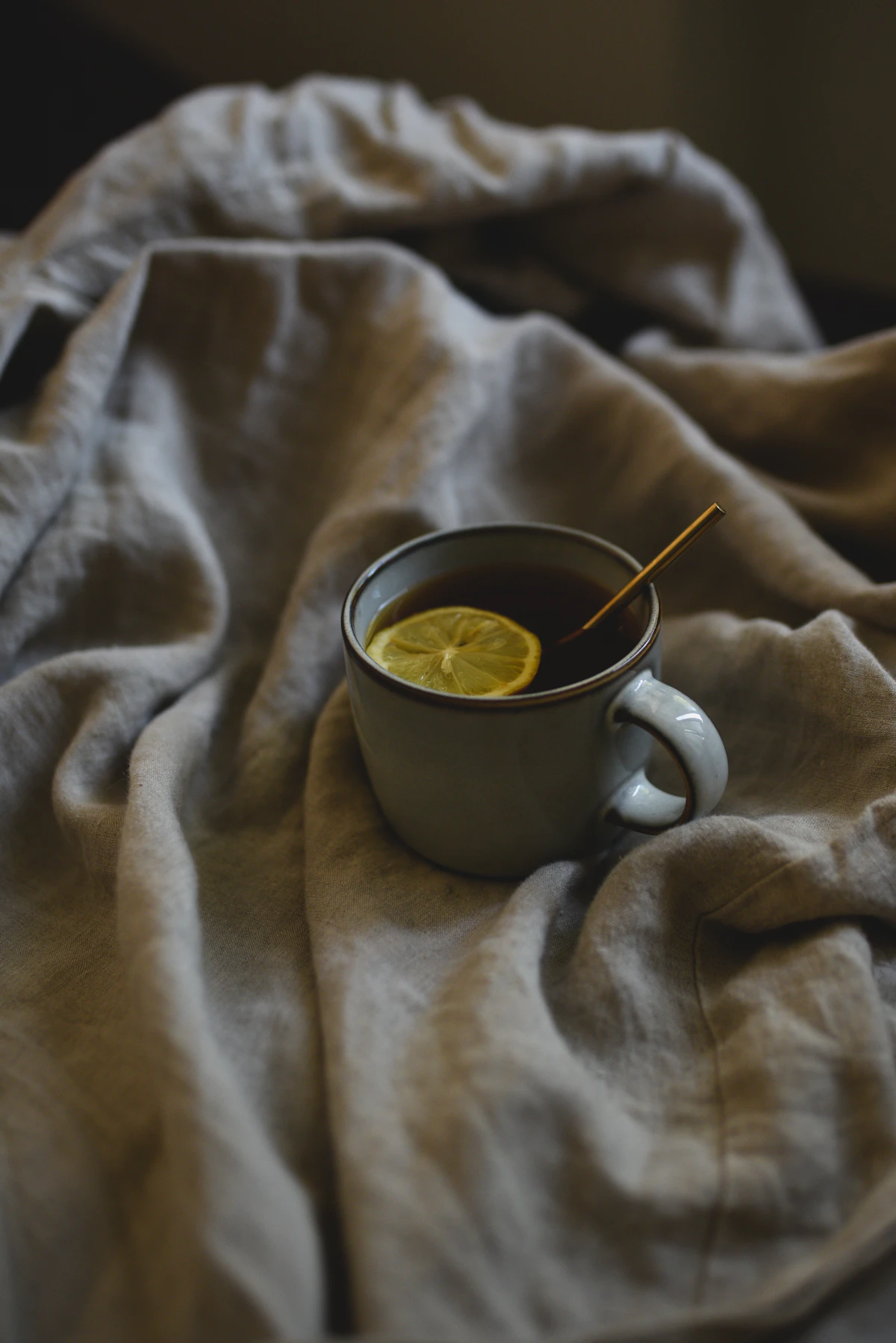 A warm cup of coffee resting on a soft, cozy blanket