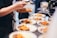 Close-up of a chef plating a colorful, fresh dish in a modern kitchen setting.