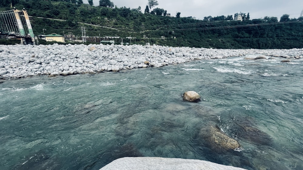 a river with rocks and a bridge