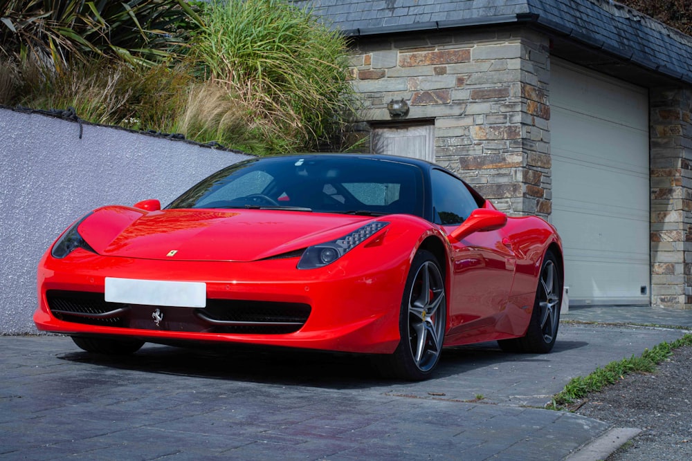 a red sports car parked in front of a garage