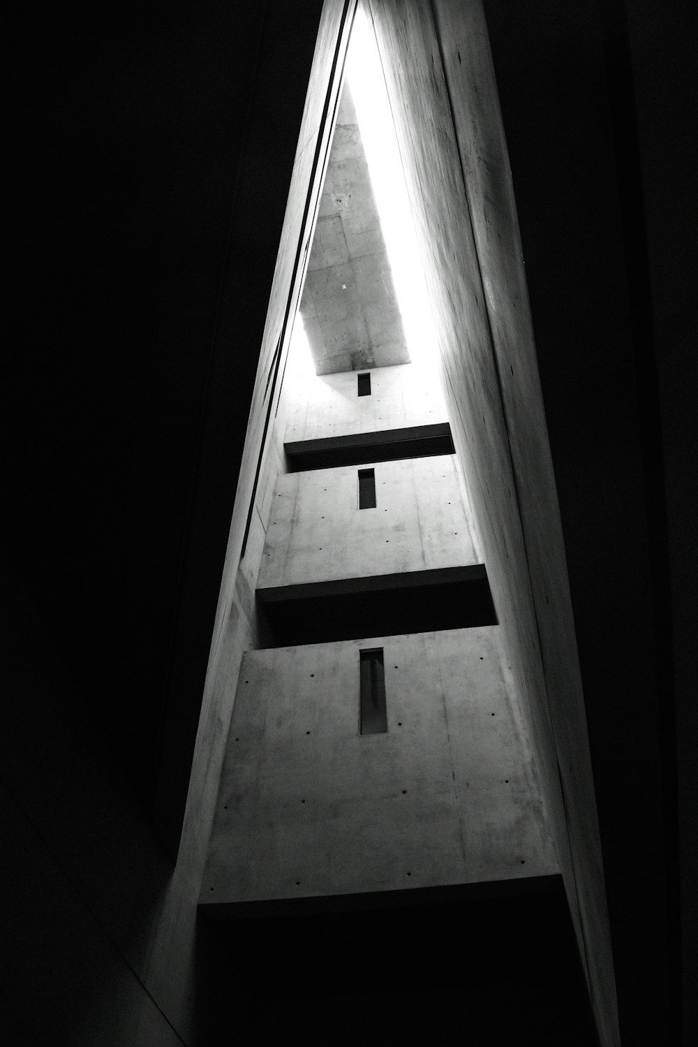 a black and white photo of a building with a light on the top