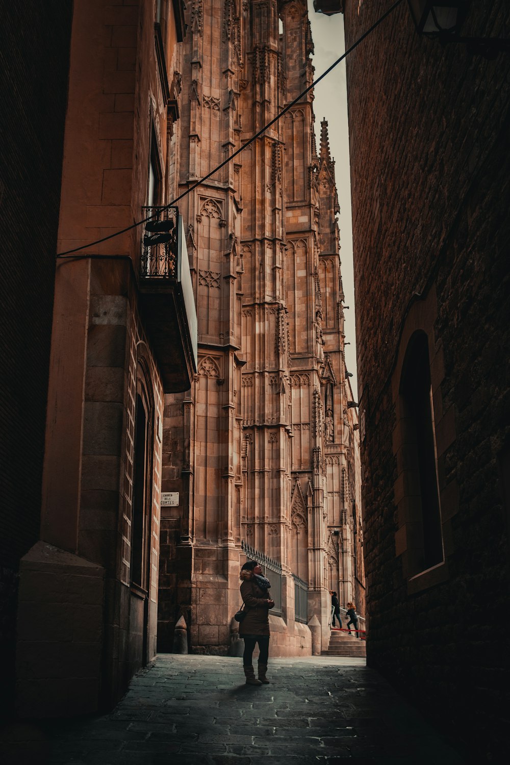 a person walking down a street between buildings