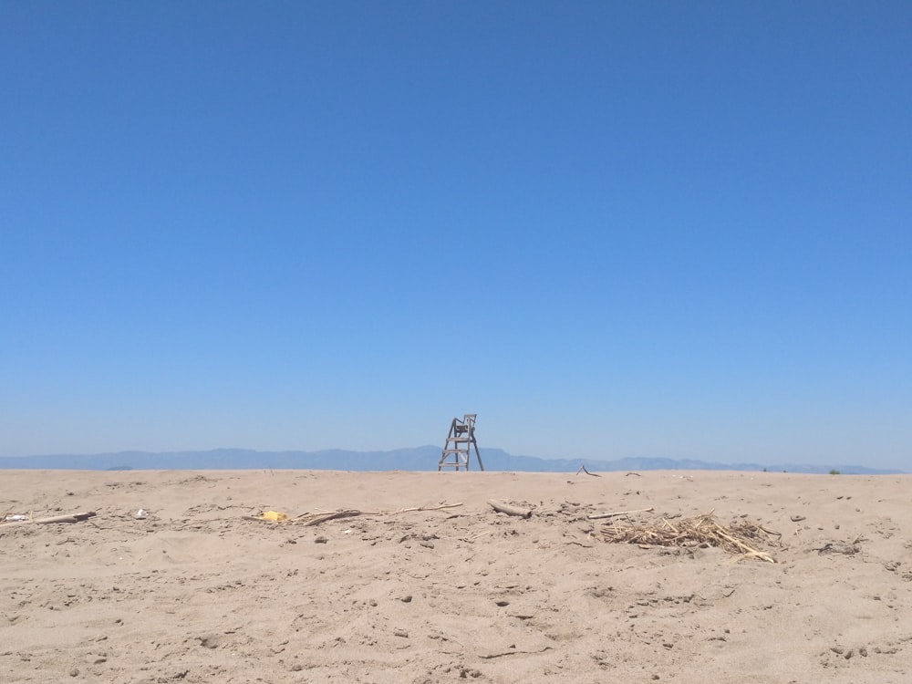 a sandy area with a tower in the distance