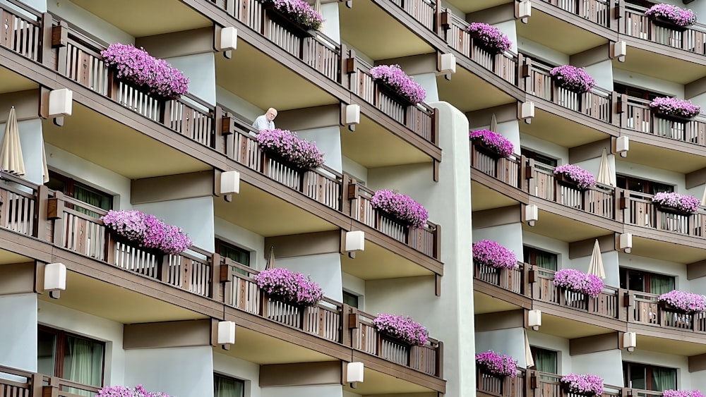 a building with many balconies and flowers on the windows