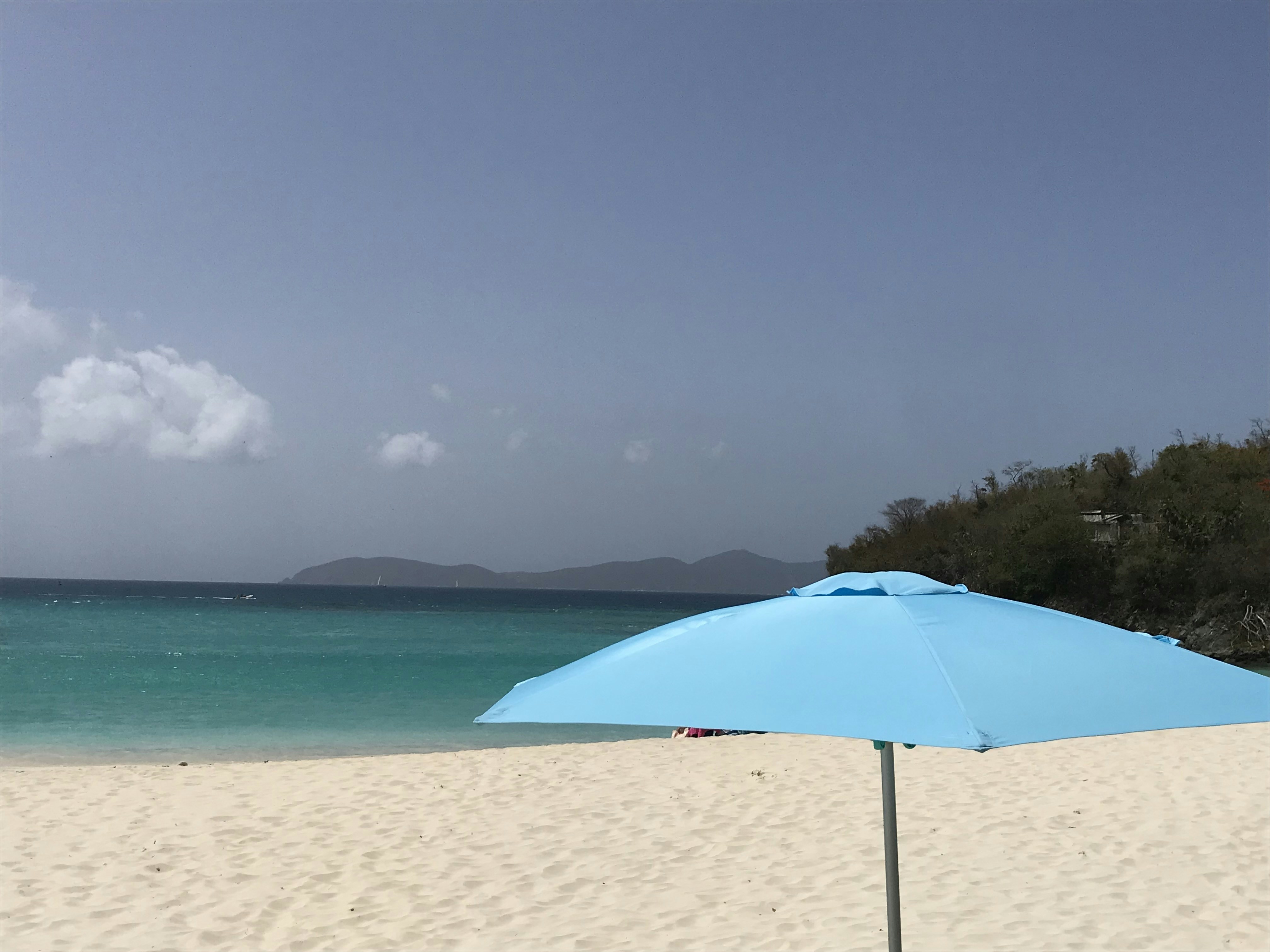a beach with an umbrella, 