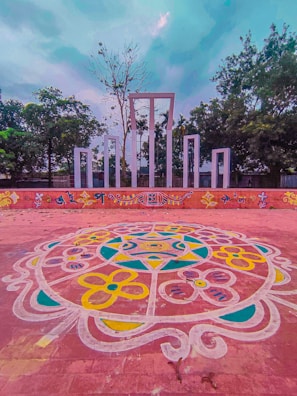 The temple courtyard decorated with colorful rangoli and flowers for a festival.