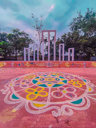 Colorful rangoli and floral arrangements at the entrance of a Brahmakamal Trust event