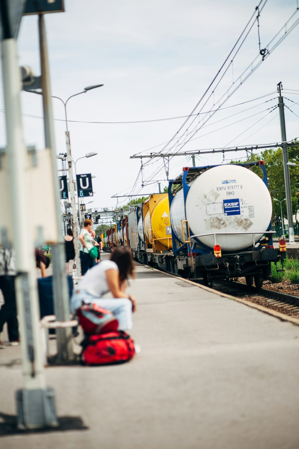 a person sitting on a bench next to a train