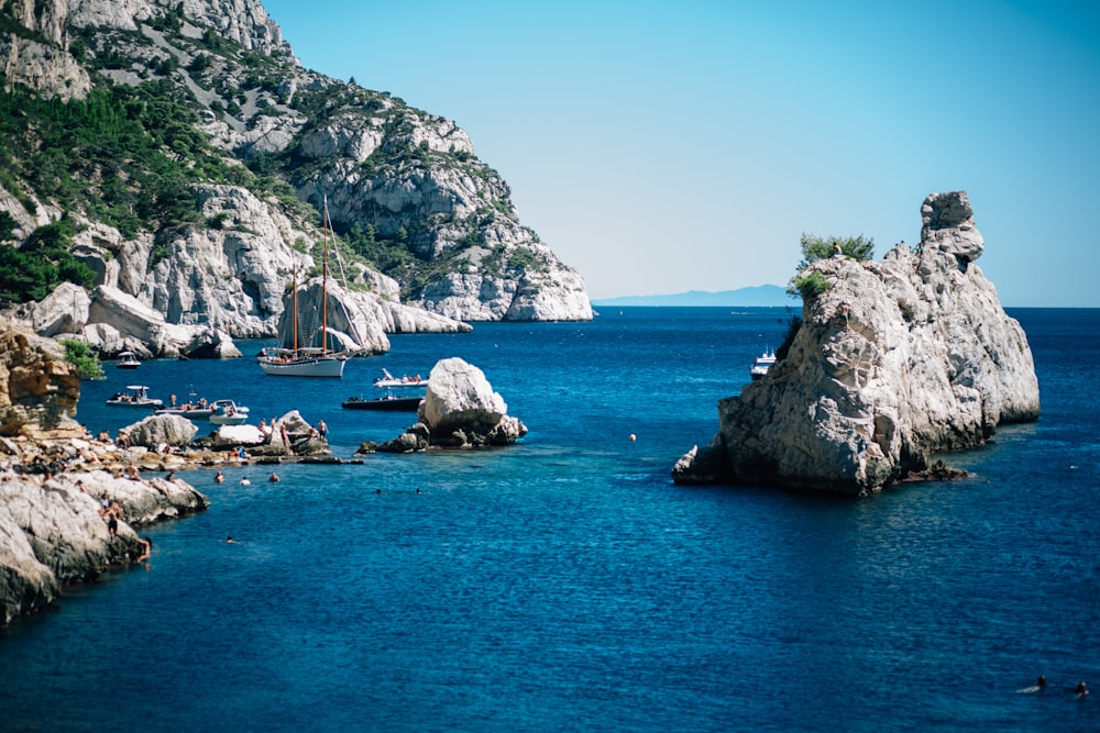 a body of water with boats and rocky cliffs