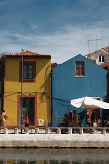 a group of people standing outside of a colorful building