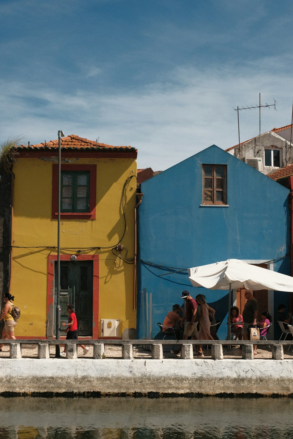 a group of people standing outside of a colorful building