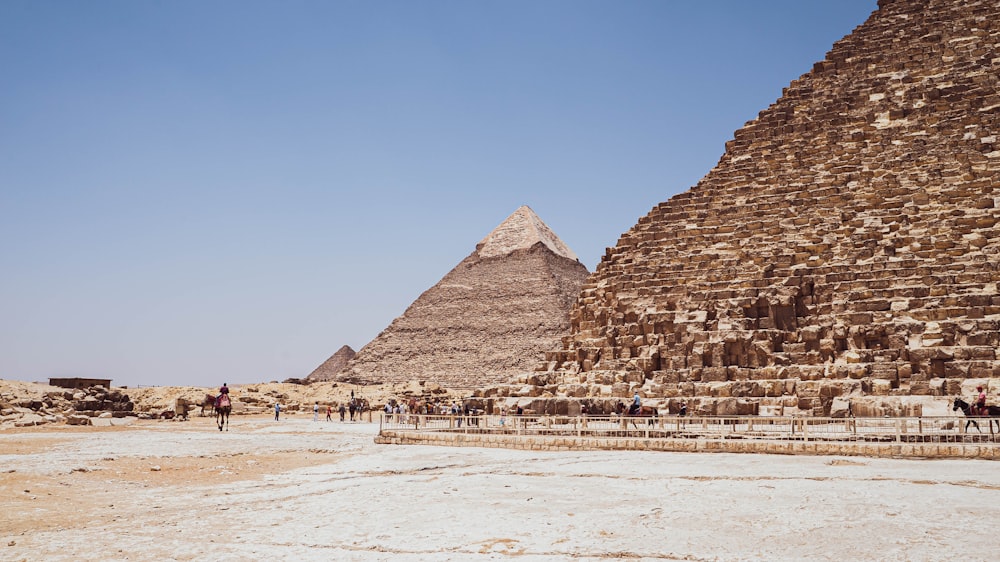a group of people walking around a pyramid