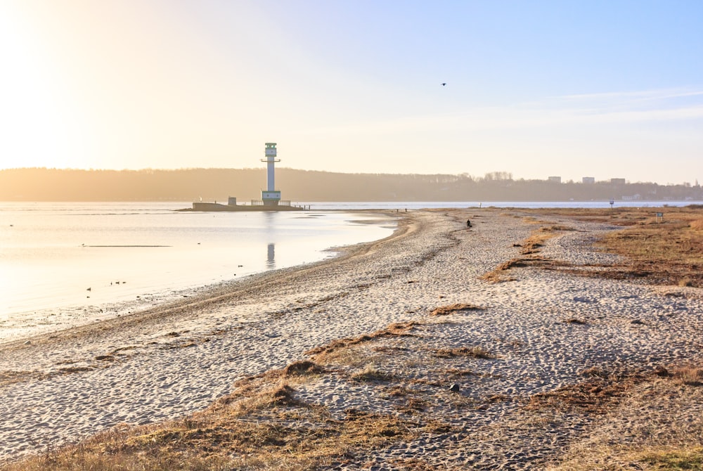 a large body of water with a lighthouse in the distance