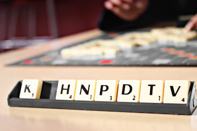 Close-up of a player’s hand selecting letters on the Canuckle game board.