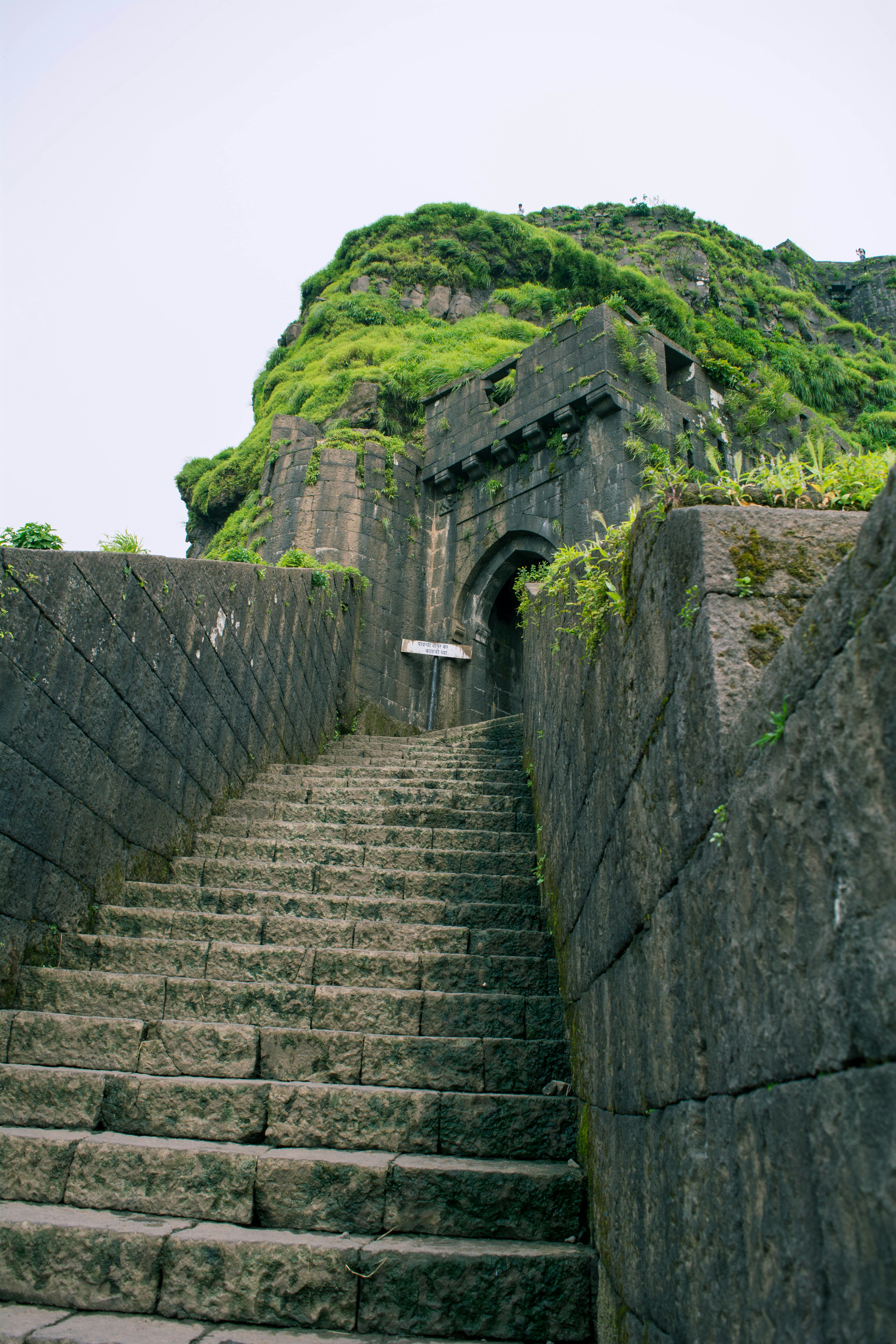 Stone staircase climbing the ancient walls of a Maharashtra fort in India, showing the scale and construction of Maratha-era stone architecture.