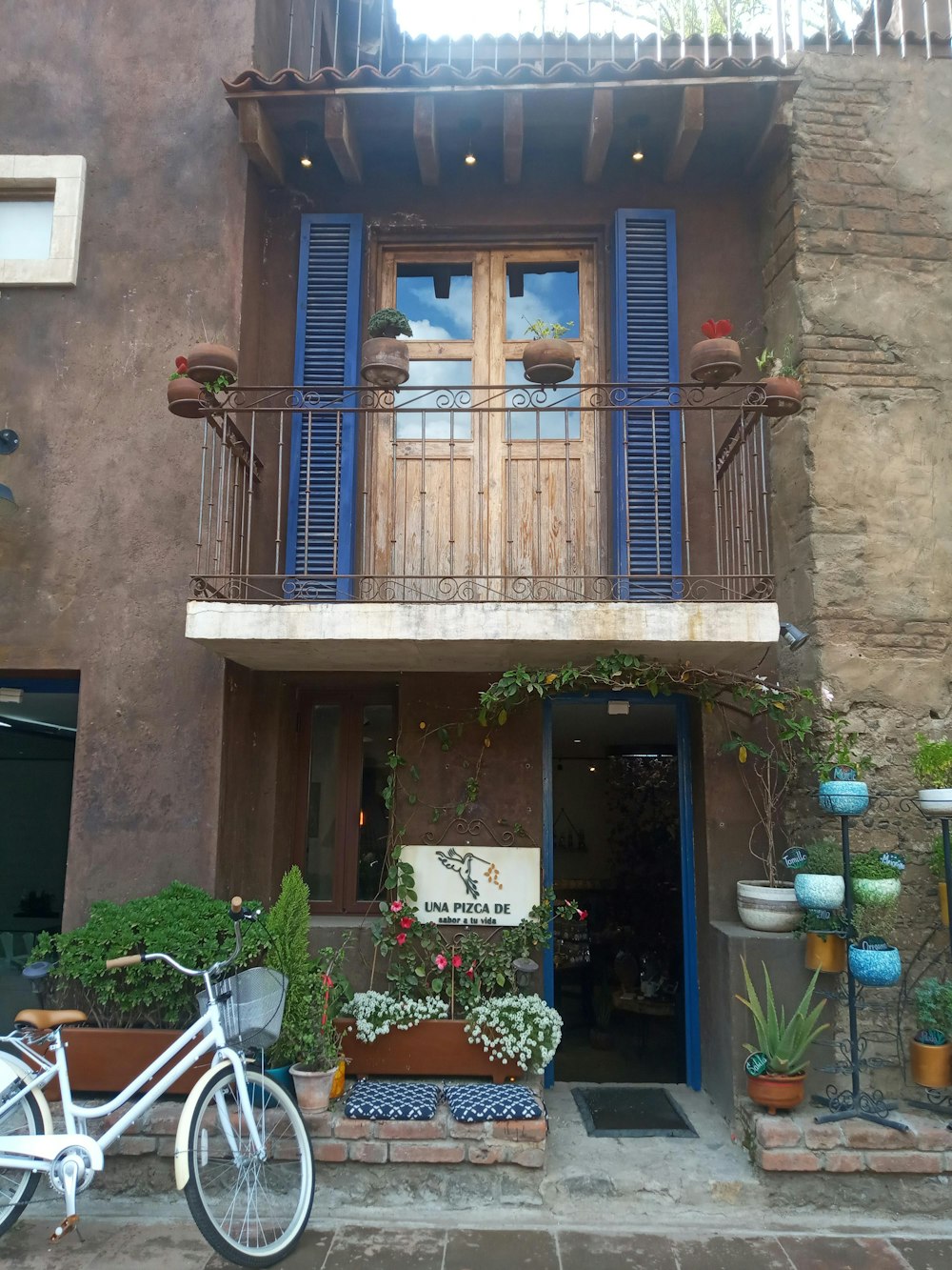 a bicycle parked in front of a building with blue shutters