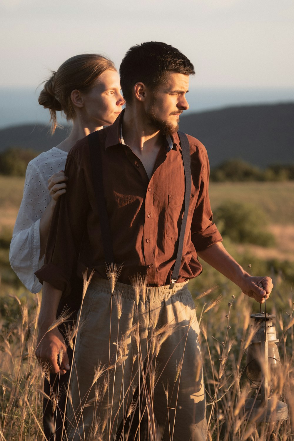 a man and woman standing in a field