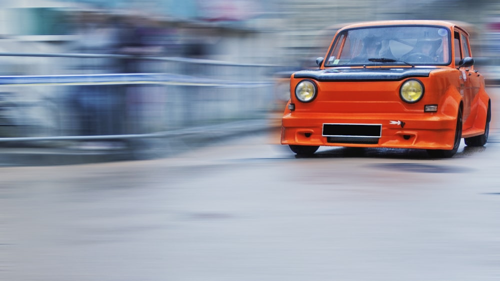 an orange car on a road