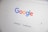 The homepage of a search engine is displayed, featuring a colorful, multi-letter logo at the top. Below the logo is a search bar with a microphone symbol and two buttons labeled 'Google Search' and 'I'm Feeling Lucky'.