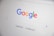 The homepage of a search engine is displayed, featuring a colorful, multi-letter logo at the top. Below the logo is a search bar with a microphone symbol and two buttons labeled 'Google Search' and 'I'm Feeling Lucky'.