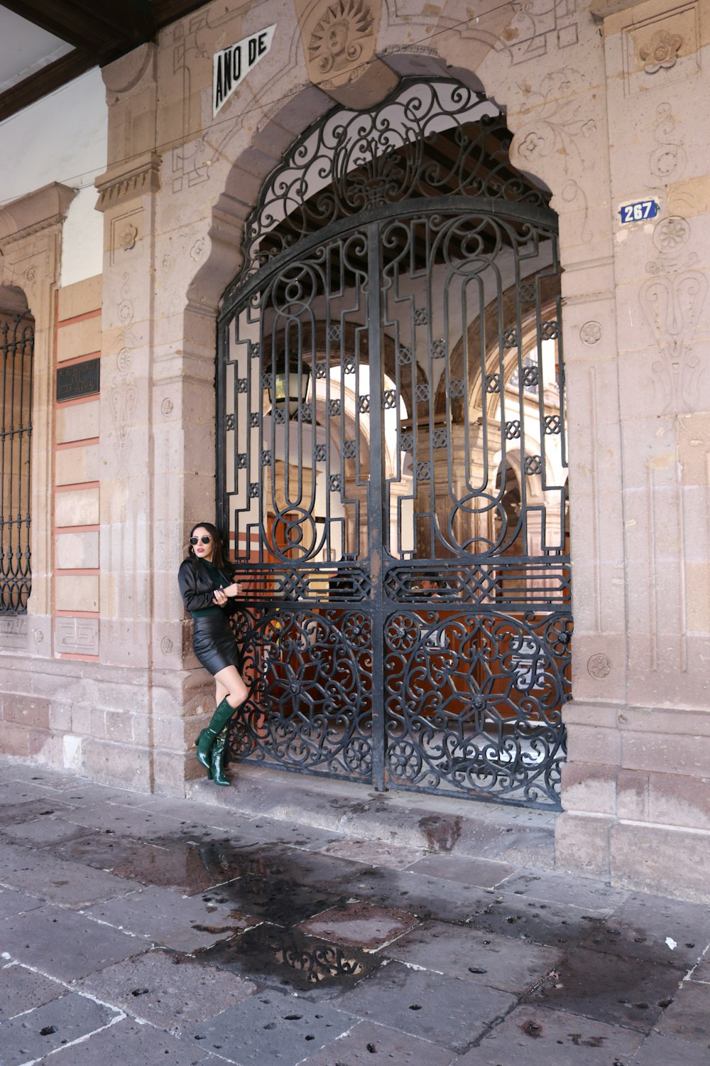 a person posing in front of a gate