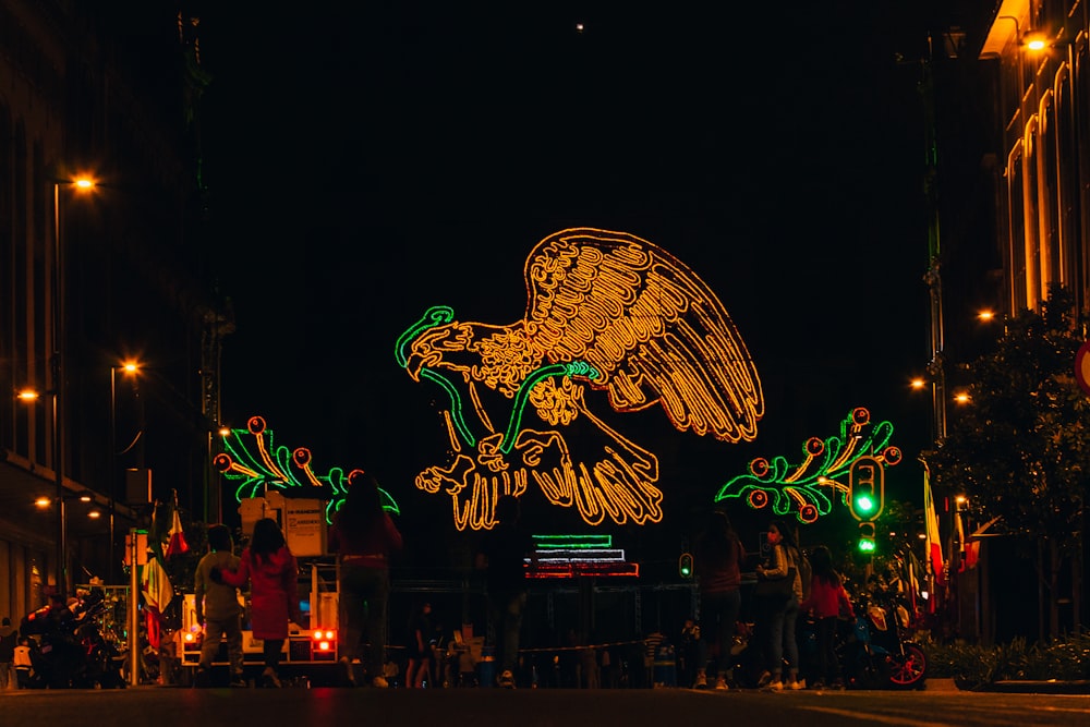 un groupe de personnes debout autour d’un grand panneau lumineux