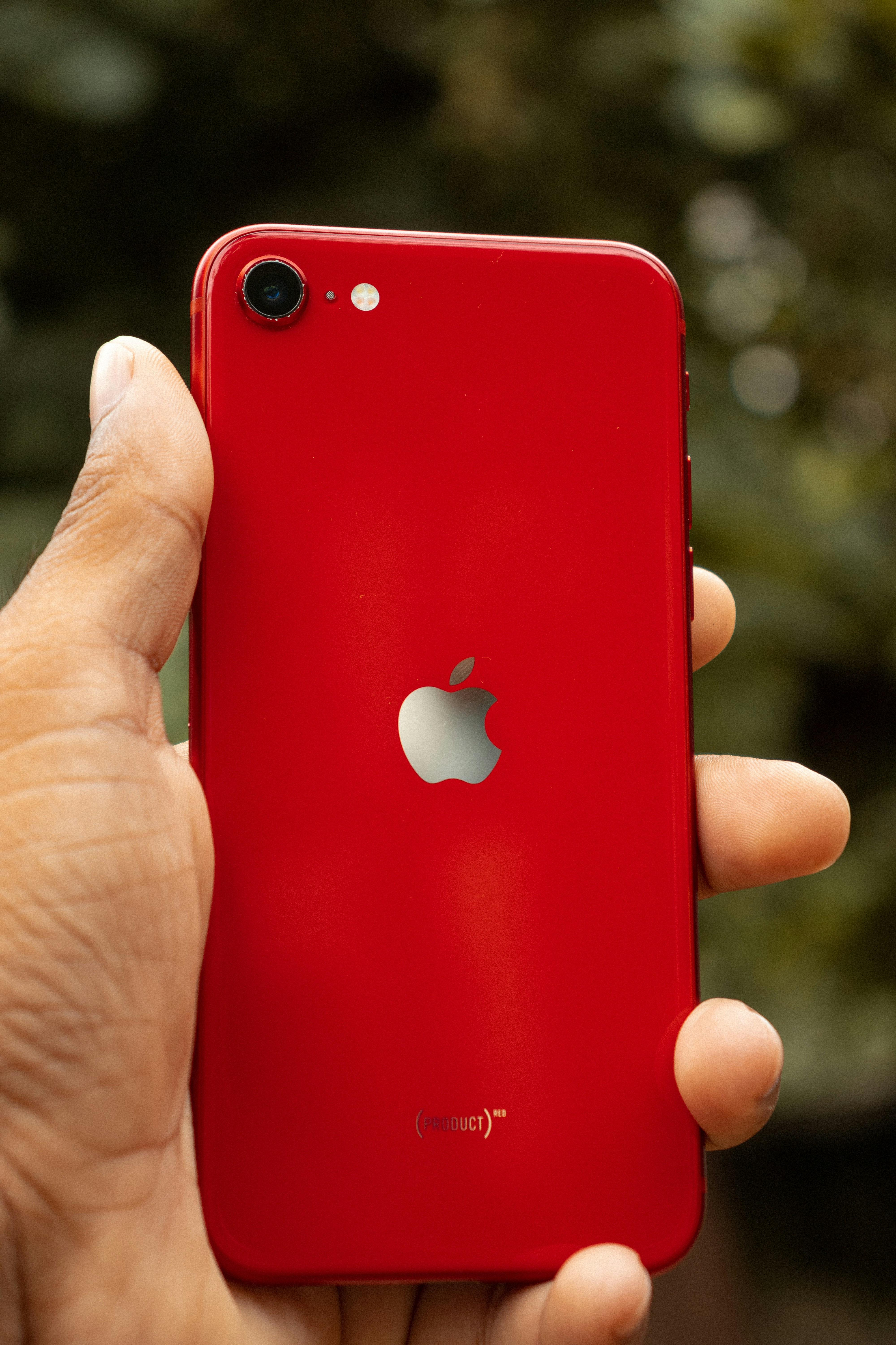 a hand holding a red cell phone