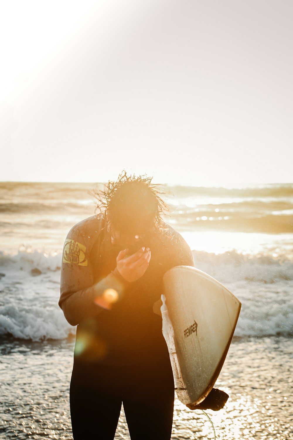 a person holding a surfboard on a beach