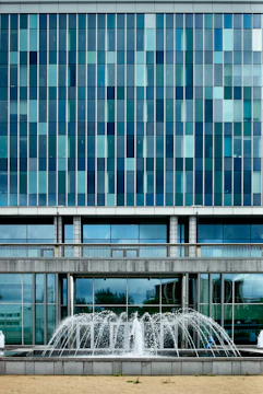 Commercial building facade being pressure washed, water droplets sparkling.