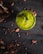 Close-up of a vibrant green smoothie and natural vitamin capsules on a wooden table.