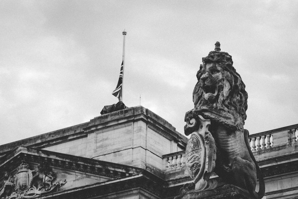 una statua di un leone con una bandiera sopra di esso