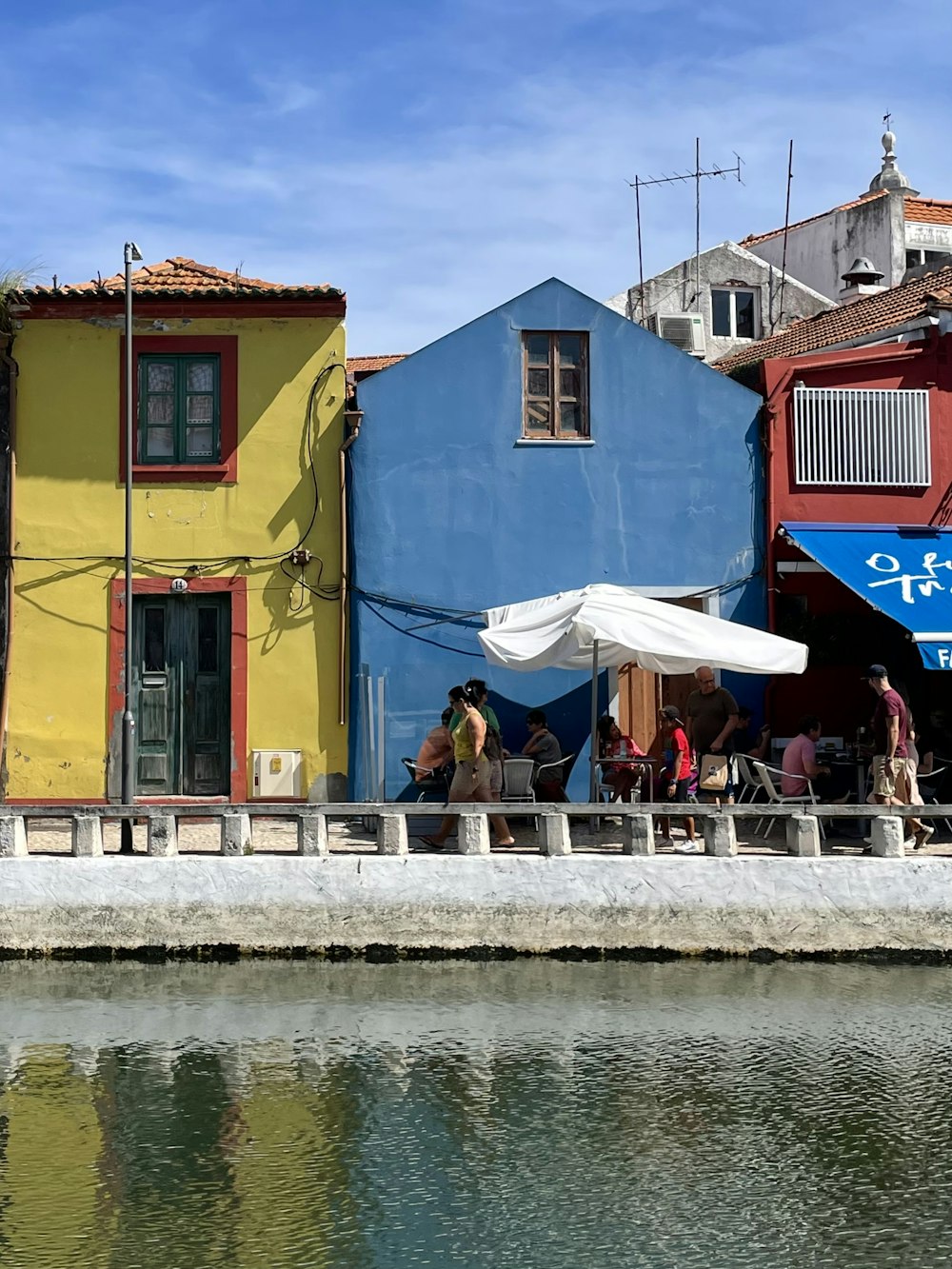 a group of people sitting on a dock by a body of water