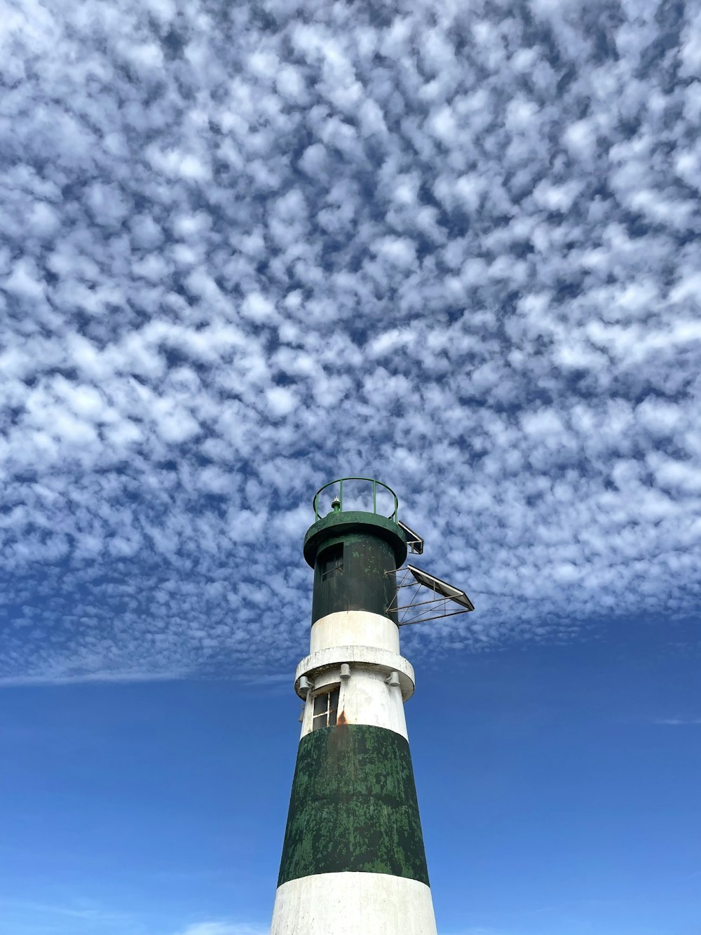 a light house with a cloud of smoke behind it