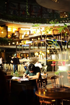 An artist writing lyrics in a cozy café.