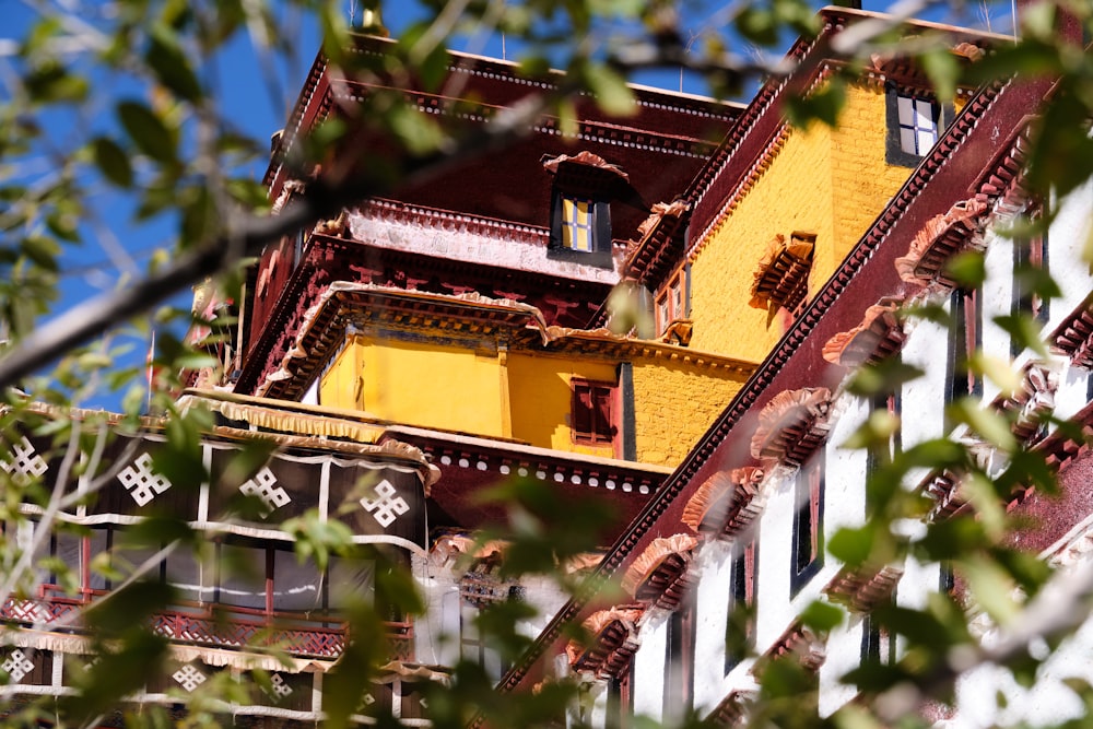 a yellow pagoda with a tree in front of it