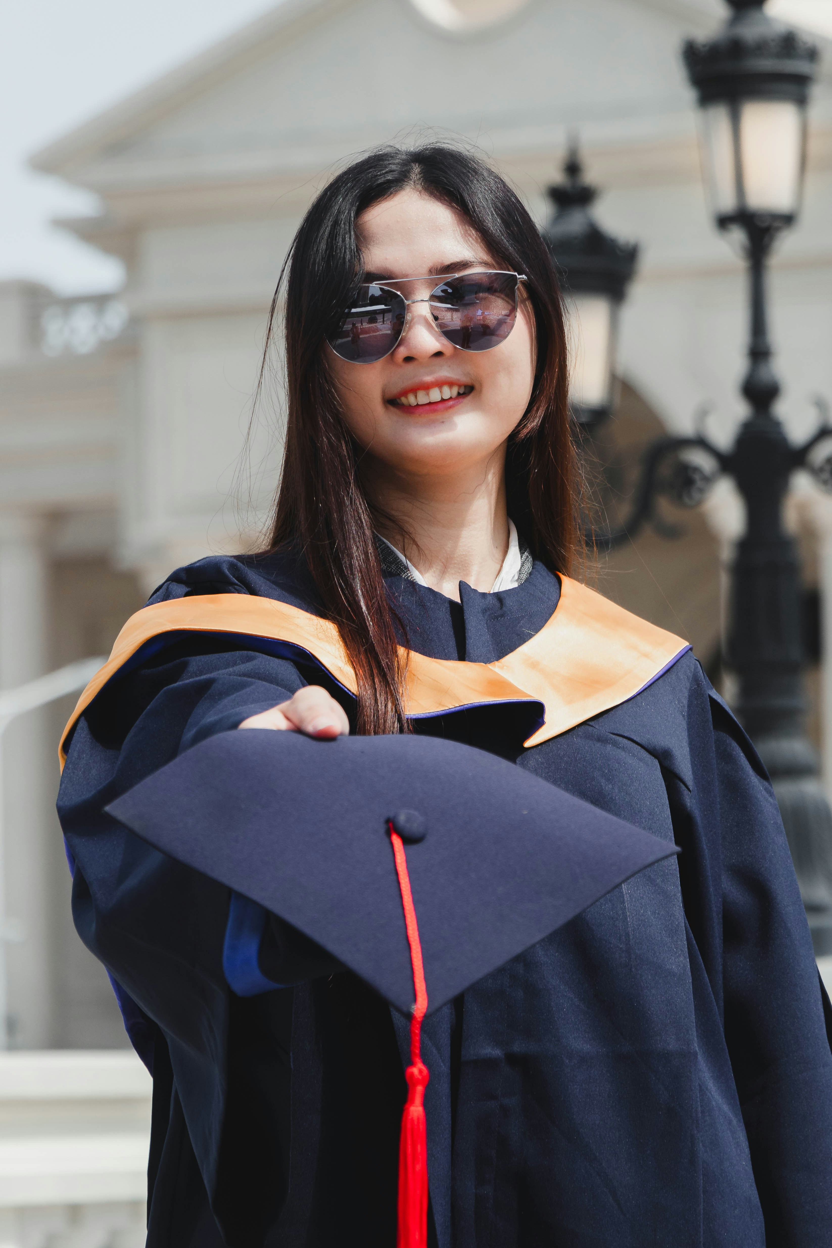 a person wearing sunglasses and a black jacket with a red ribbon