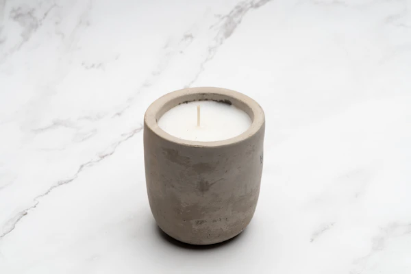 Minimalist candle holders carved from creamy white stone, softly glowing with candlelight.