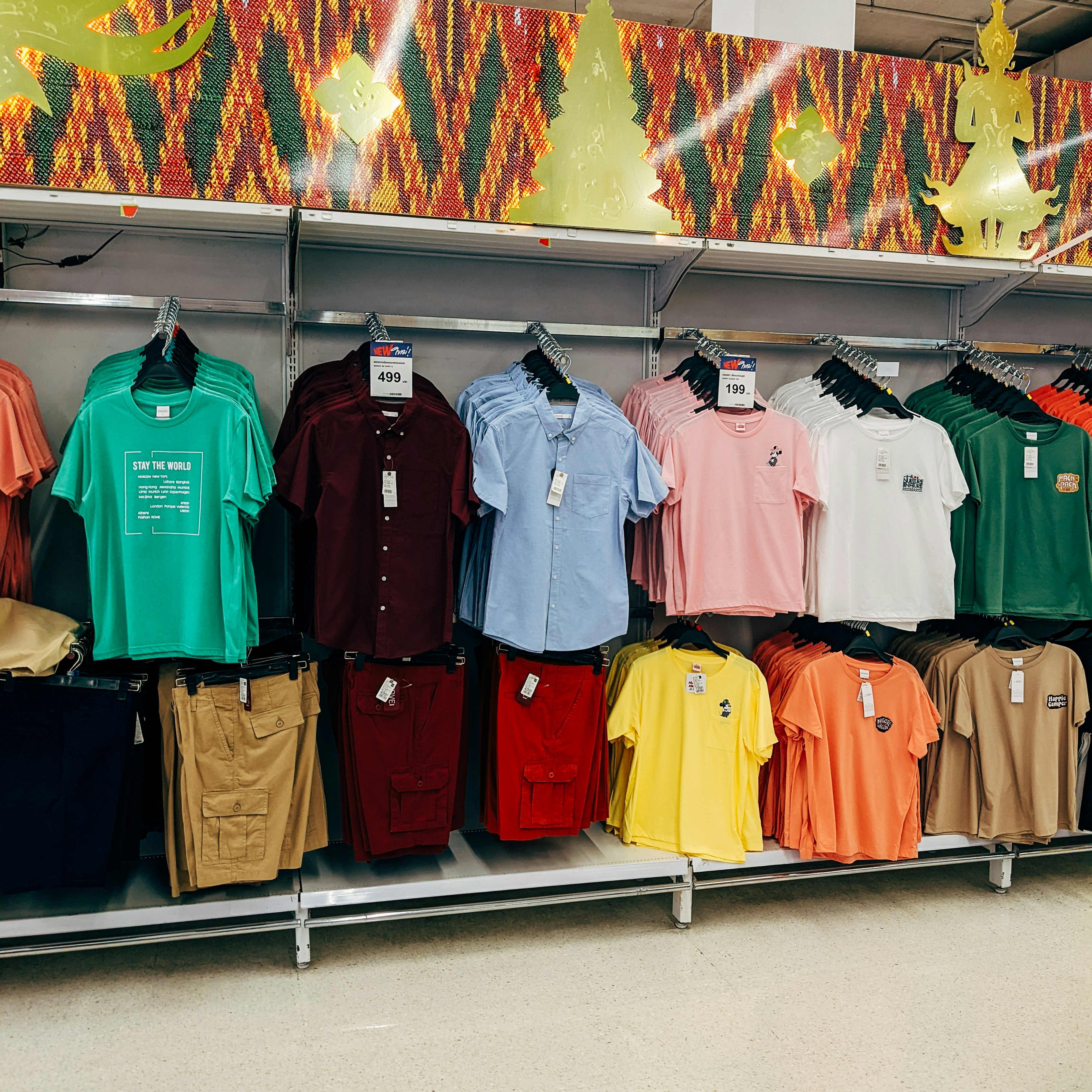 Bermudas masculinas coloridas e shorts em araras de loja, ambiente claro e organizado