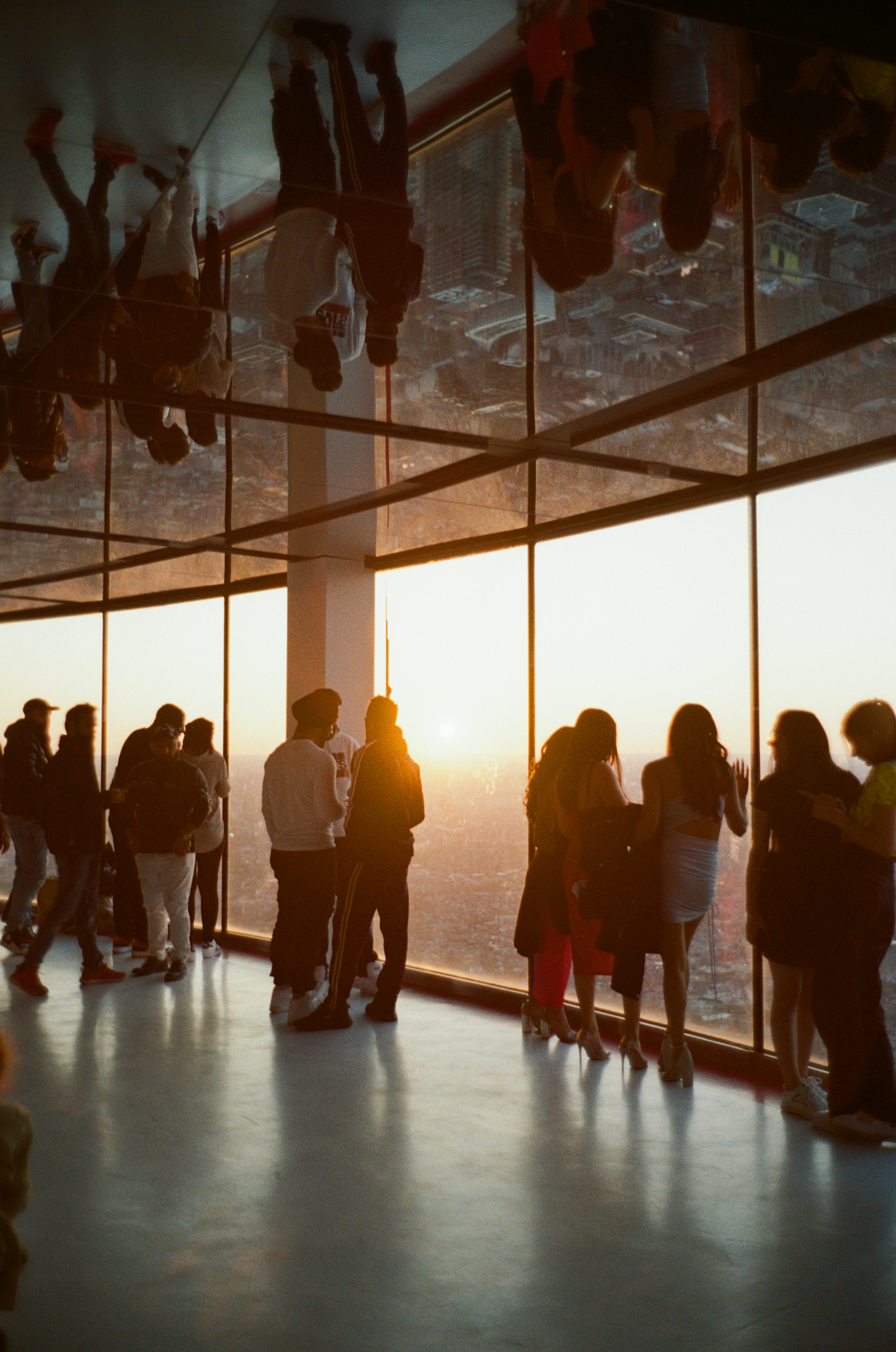 a group of people standing in a room with a large window