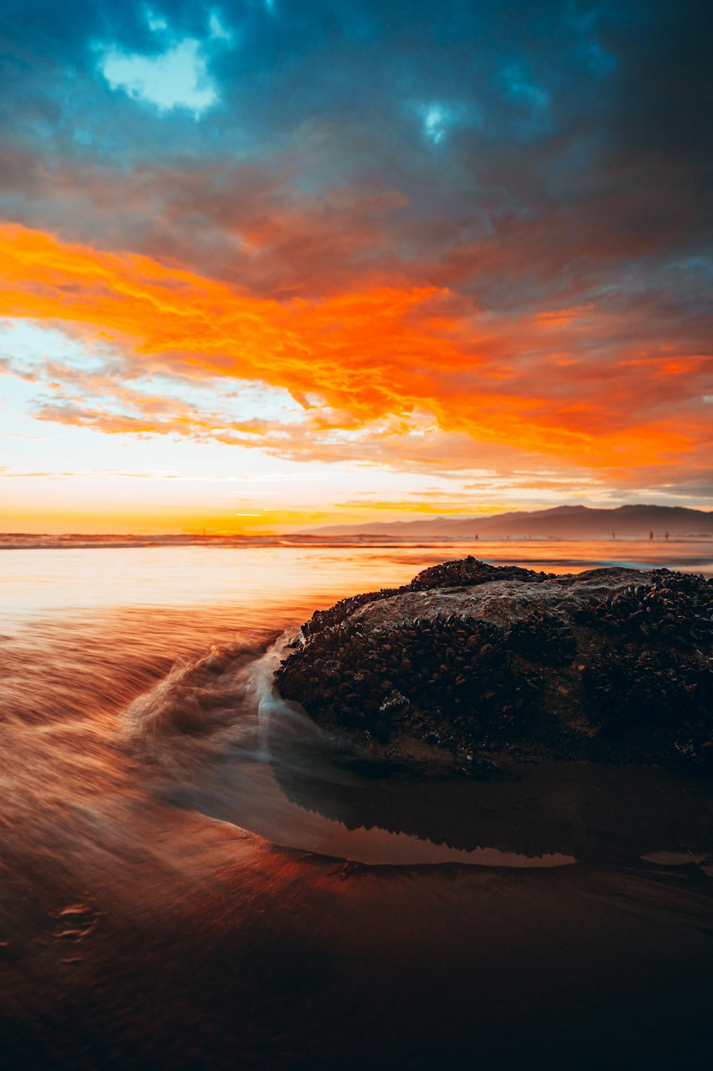 a rocky beach with a sunset