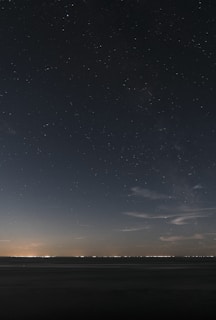 a starry night sky over a beach