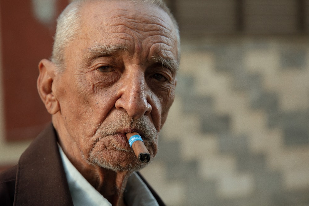 a man with a blue pen in his mouth