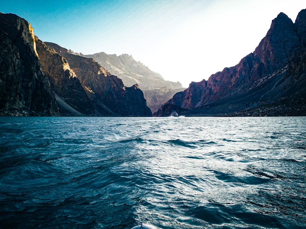 a body of water with a rocky shoreline with Tracy Arm in the background