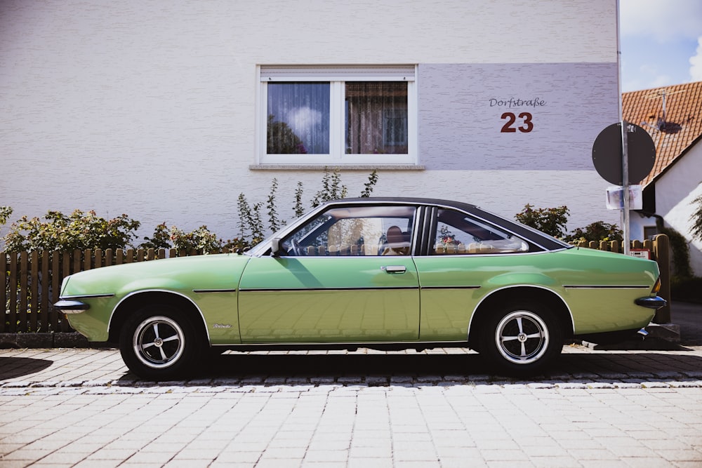 a green car parked on the side of a road