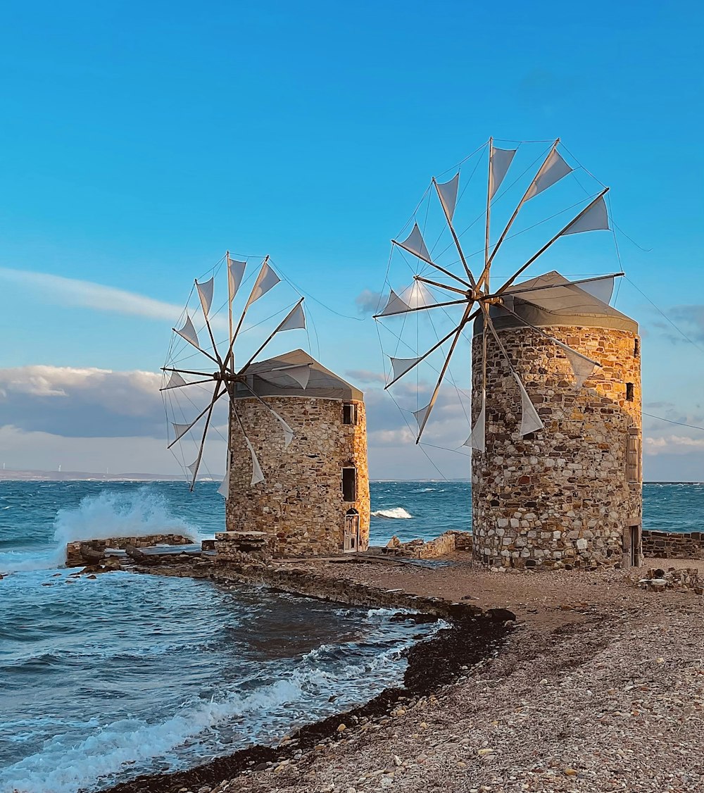 mulini a vento su una spiaggia con Chios sullo sfondo
